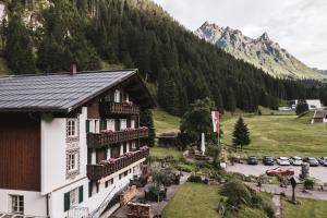 ein Gebäude mit Blumen auf den Balkonen vor einem Berg in der Unterkunft Alpenhotel Heimspitze in Gargellen