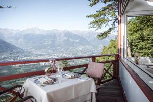 d'une table sur un balcon avec vue sur les montagnes. dans l'établissement Relais & Chateaux Hotel Castel Fragsburg, à Merano