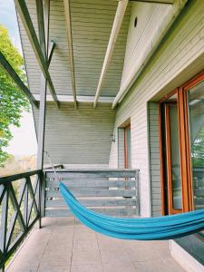 a hammock on the porch of a house at Spacious family house in the city centre in Pāvilosta