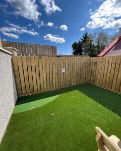 a backyard with a wooden fence and green grass at Glenside Abbey 'Sleeping 7 guests' in Buncrana