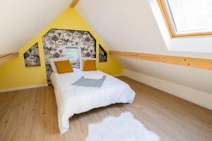 a bedroom with a large bed in a attic at Gîte de charme refait à neuf, à Rimbach en Alsace. in Rimbach-près-Guebwiller