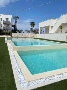 a swimming pool in front of a building at Tuo Hotel in Polignano a Mare
