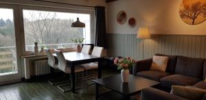 a living room with a couch and a table and a window at Appartement Nordenau in Schmallenberg