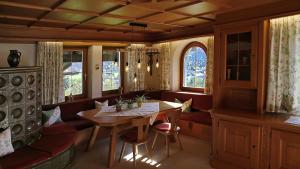 ein Esszimmer mit einem Tisch, Stühlen und Fenstern in der Unterkunft Ferienwohnung Elisa in Schruns-Tschagguns