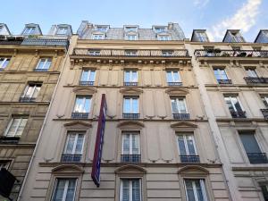 un edificio con una bandera púrpura delante de él en Timhotel Odessa Montparnasse, en París
