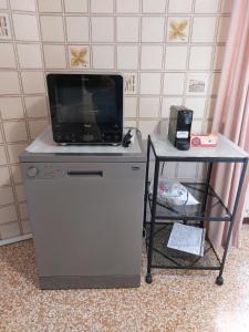 une télévision au-dessus d'une commode avec une table dans l'établissement Appartamento Todaro, à Vigevano