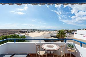 d'un balcon avec une table et des chaises et une vue. dans l'établissement 3BR Home - Private Heated Pool - Parking, à Playa Blanca