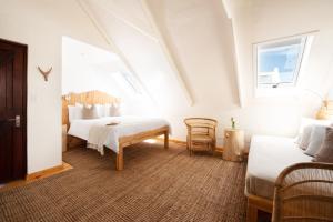 een witte kamer met 2 bedden en een raam bij Gonana Guesthouse in Paternoster