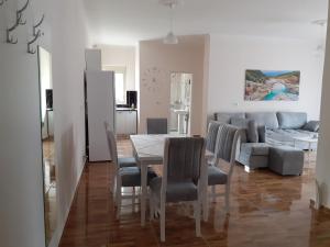 a dining room with a table and chairs and a couch at Drini Apartments in Përmet