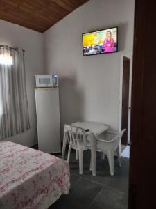 una camera con tavolo e TV a parete di Pousada Familiar Morada do Rapha a Boracéia