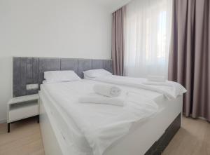 a white bed with white towels on top of it at Horizon-Two Bedroom Apartment Partial Sea View Charlene in Becici +30 photos