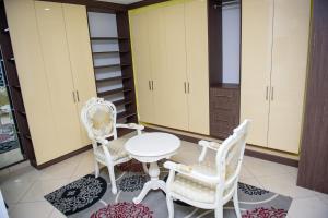eine Küche mit weißen Stühlen, einem Tisch und Schränken in der Unterkunft Cc & Cg Homes 4 Bedroom Duplex-24Hrs Electricity WIFI Security in Abuja