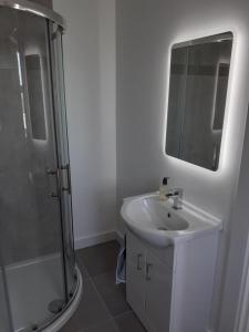 a white bathroom with a sink and a shower at An Sean Teach in Fodry