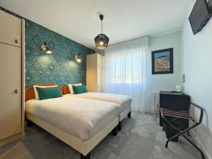 1 dormitorio con 1 cama grande y 1 silla en Hôtel l'Albatros, en Damgan