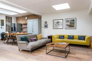 uma sala de estar com um sofá e uma mesa em Stunning 3BD Flat Shoreditch with Hidden Garden em Londres