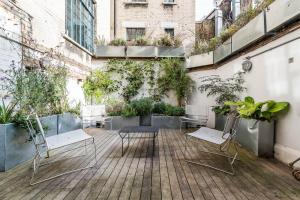 ロンドンにあるStunning 3BD Flat Shoreditch with Hidden Gardenの建物内のパティオ(椅子、植物付)