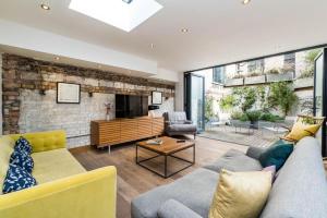 uma sala de estar com um sofá e uma lareira em Stunning 3BD Flat Shoreditch with Hidden Garden em Londres
