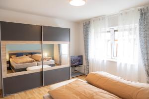 1 Schlafzimmer mit 2 Betten und einem großen Spiegel in der Unterkunft Casa Katharina in Wald-Michelbach