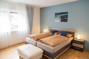 a bedroom with a bed and a stool and a window at Casa Katharina in Wald-Michelbach