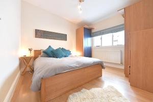 a bedroom with a bed with blue pillows on it at Gorgeous 3BD Cottage in the Heart of Guildford in Guildford