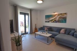 a living room with a blue couch and a table at Luxury apartment Punta with sea view and swimming pool in Premantura