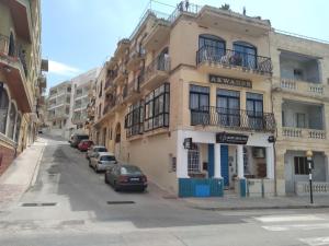 un edificio en una calle con coches aparcados delante en Mayfair, en Marsaskala