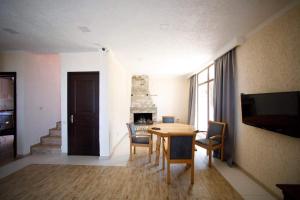 a living room with a table and a fireplace at kaprovani Kako in Shekhvetili