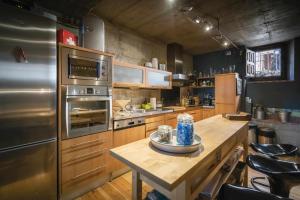 a large kitchen with a wooden table and stainless steel appliances at Loft Rural LaCalata in Calatañazor