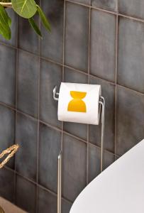 un supporto di carta igienica con un simbolo giallo di Finest Retreats - ARC Painswick a Painswick