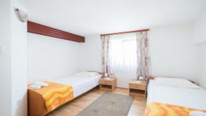 a bedroom with two beds and a window at Apartments Ana & Bogdan in Postira