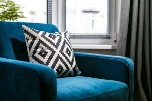 a blue couch with a black and white pillow on it at Sutton House by Pureserviced in Plymouth