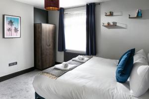 a bedroom with a large white bed with blue pillows at Sutton House by Pureserviced in Plymouth