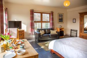 1 dormitorio con 1 cama y sala de estar en Kirkaig Lodge en Lochinver