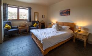 1 dormitorio con 1 cama, 1 sofá y 1 silla en Kirkaig Lodge en Lochinver
