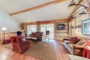 a living room with wooden walls and furniture in a cabin at Swiss Village in Pagosa Springs