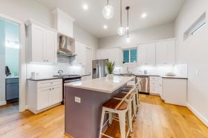 a kitchen with white cabinets and a large island at In the Heights in Houston
