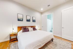 a white bedroom with a large bed and a window at In the Heights in Houston