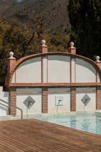 una piscina con un arco sobre el agua en Posada Morisca Charming Hotel Boutique, en Frigiliana