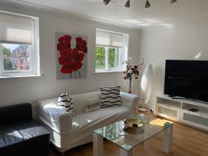 a living room with a white couch and a tv at Destination London Docklands in London