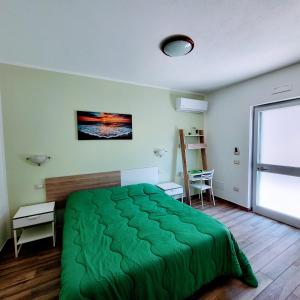 a bedroom with a green bed and a window at B&B da AnnaMaria in Maratea