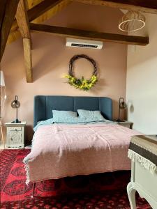 een slaapkamer met een blauw bed en een krans aan de muur bij Kiss-Henézi Guest House Mád Tokaj in Mád