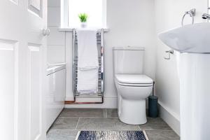 Baño blanco con aseo y lavamanos en The Knavesmire - Quaint Victorian Home With Free Parking en York