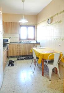 a kitchen with a table with a yellow table cloth on it at Casa maria in Puerto del Rosario