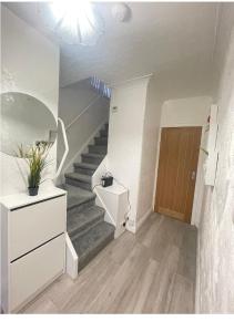 een hal met een trap met een deur en een trap bij Modern 3 bedroom house, 3 Bathroom, secure parking, Wi-Fi & Garden in Leeds
