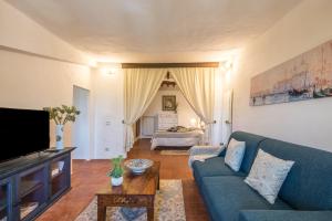 Appartamento Panoramico في Radicondoli: غرفة معيشة مع أريكة زرقاء وسرير