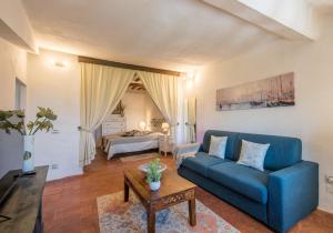 sala de estar con sofá azul y mesa en Appartamento Panoramico en Radicondoli