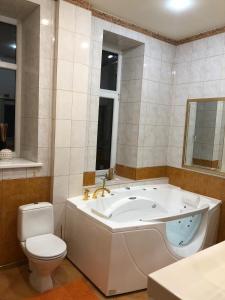 een badkamer met een bad en een toilet bij Classical large apartment on Alberta street, FREE PARKING in Rīga