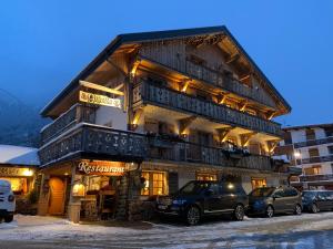 budynek z samochodami zaparkowanymi przed nim w obiekcie Les Chalets de La Griyotire w mieście Praz-sur-Arly