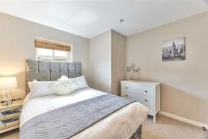 a bedroom with a large bed and a dresser at High Level - Properties Unique in Gateshead