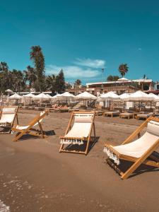 eine Gruppe von Liegestühlen und Sonnenschirmen am Strand in der Unterkunft Kalia Beach Hotel Side in Side
